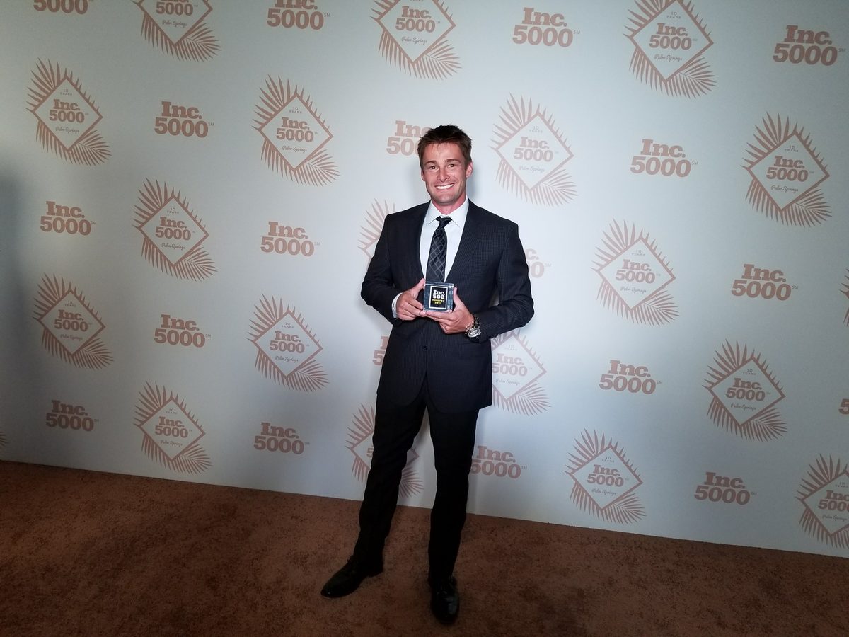 Chris Rickerson holding the Inc. 5000 award trophy at the 2017 Inc. 500 ceremony